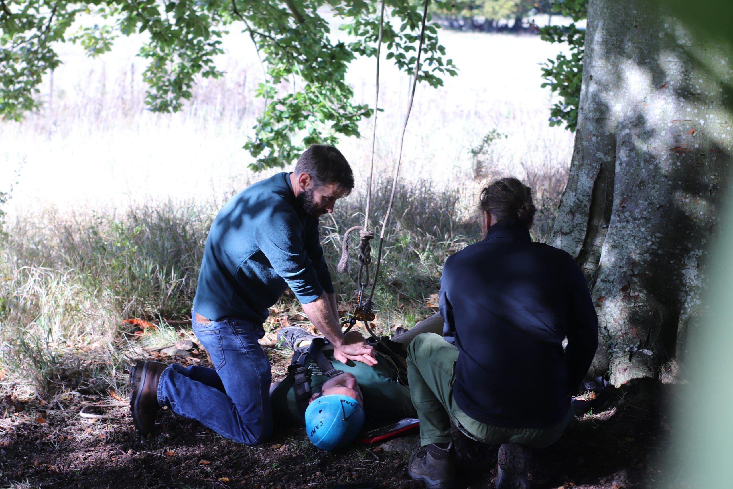 Two arborists applying first aid to a casualty